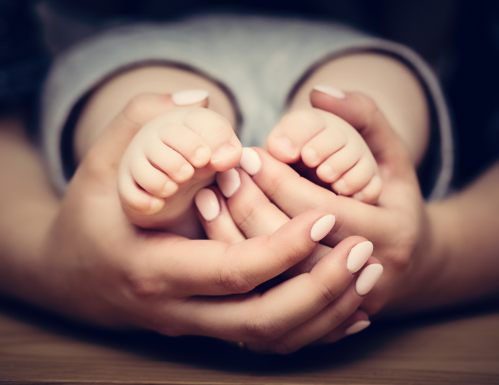 safe families benefit cardv woman holding baby's feet