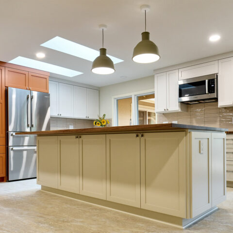 Kitchen Design by Henderer Design+ Build + Remodel, kitchen island with white custom cabinets and two green pendant lights hanging above the island