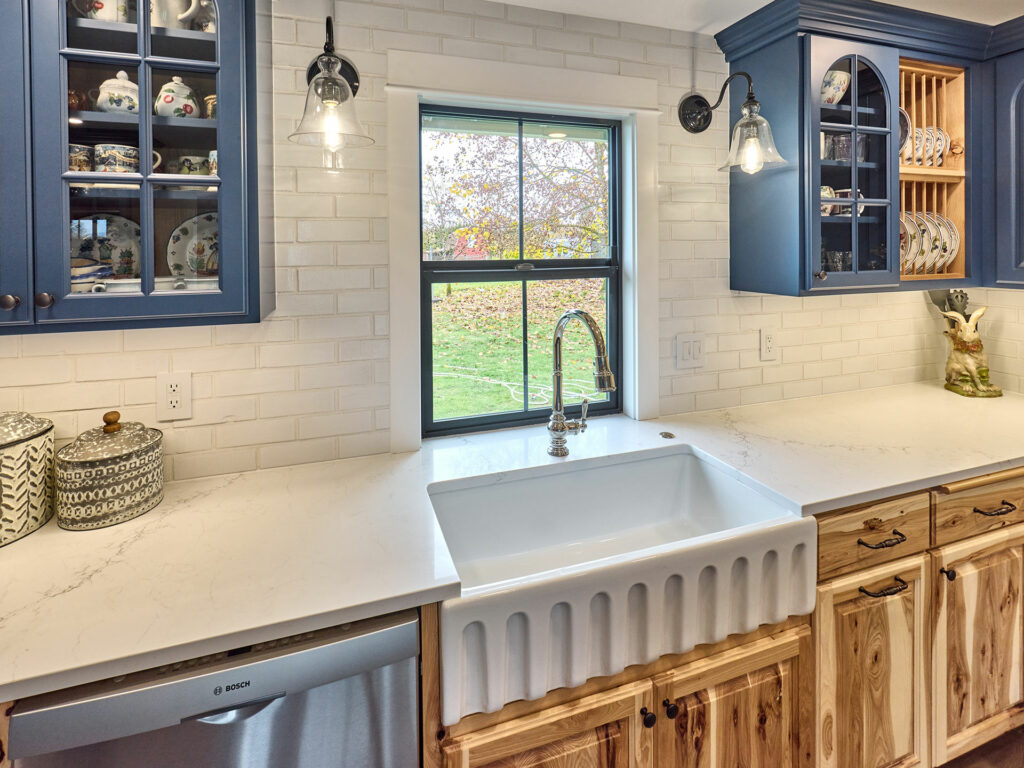 storage solutions showing glass panel cabinet faces with blue custom cabinetry and white quartz countertops